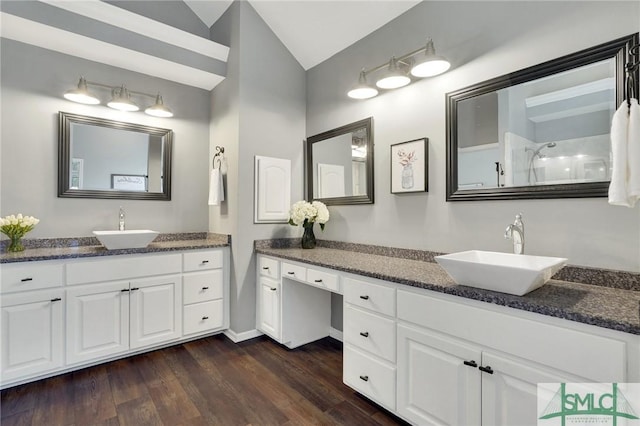 full bathroom featuring vaulted ceiling, wood finished floors, walk in shower, and a sink