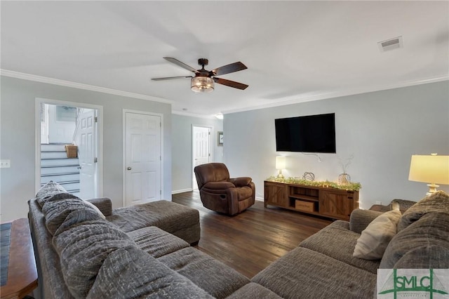 living area featuring a ceiling fan, baseboards, wood finished floors, visible vents, and ornamental molding