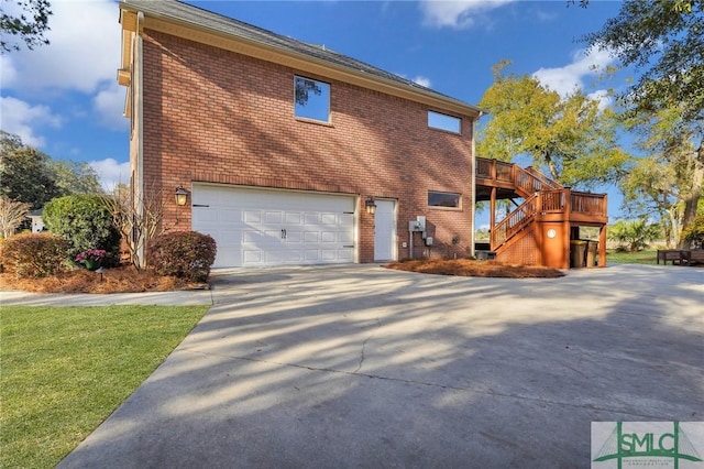 view of home's exterior with stairway, an attached garage, brick siding, and driveway