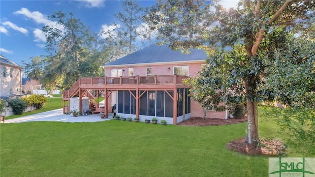 rear view of house with a yard, brick siding, a wooden deck, and a sunroom