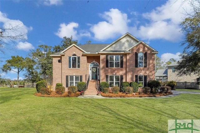 raised ranch with a front lawn and brick siding