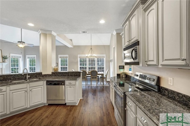 kitchen featuring dark wood-style floors, visible vents, a sink, appliances with stainless steel finishes, and ceiling fan with notable chandelier