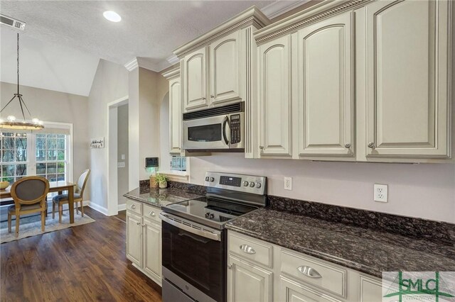 kitchen featuring visible vents, dark wood-type flooring, cream cabinets, appliances with stainless steel finishes, and an inviting chandelier