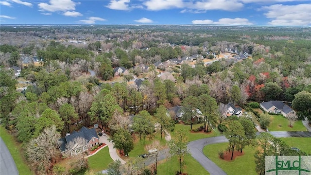 bird's eye view with a wooded view