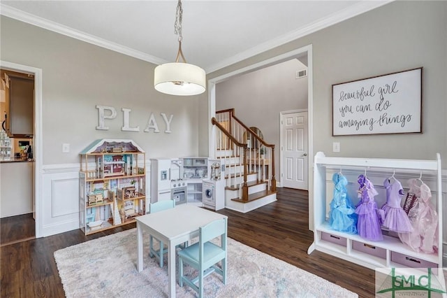 living area with stairway, wood finished floors, a wainscoted wall, visible vents, and crown molding