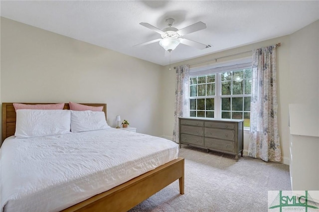 bedroom featuring light carpet, baseboards, and ceiling fan