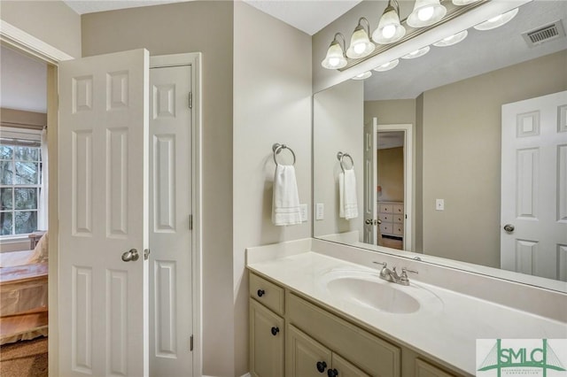 bathroom with visible vents, ensuite bath, and vanity