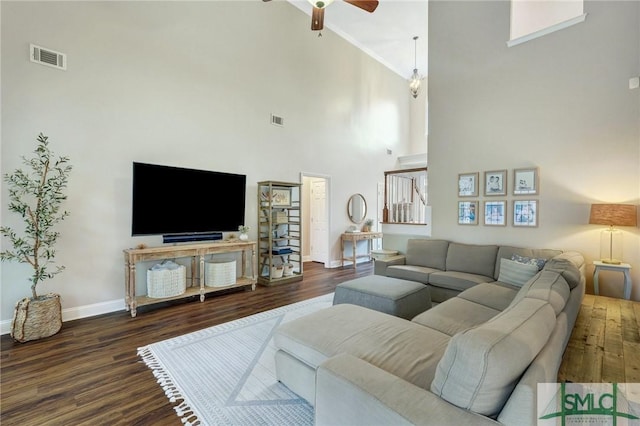 living area featuring visible vents, ceiling fan, baseboards, and wood finished floors