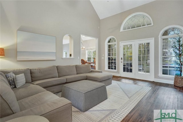 living room with wood finished floors and high vaulted ceiling