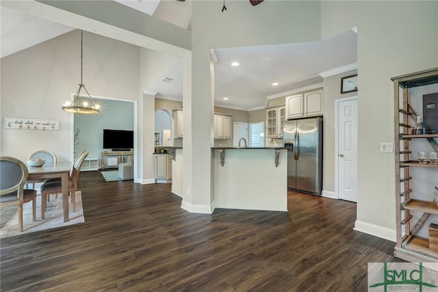 kitchen featuring dark countertops, high vaulted ceiling, stainless steel refrigerator with ice dispenser, and dark wood-style flooring