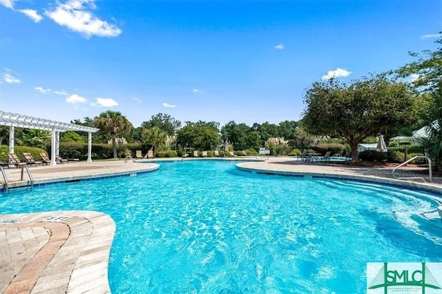 pool with a patio area and a pergola