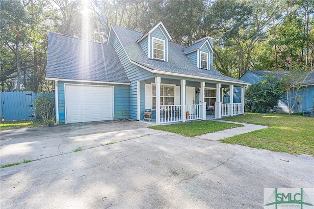 cape cod-style house featuring a shingled roof, a front yard, covered porch, a garage, and driveway