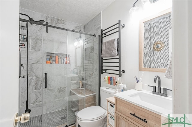 bathroom with toilet, a stall shower, vanity, and a textured ceiling