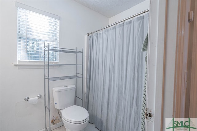 bathroom featuring curtained shower, toilet, and a textured ceiling