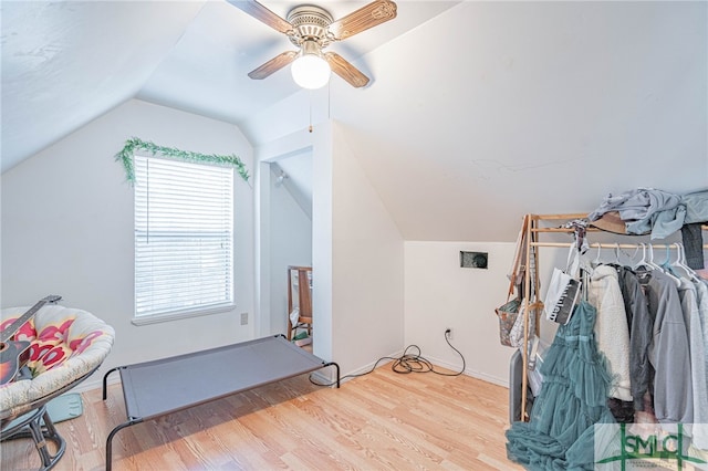 interior space featuring vaulted ceiling, a ceiling fan, and wood finished floors