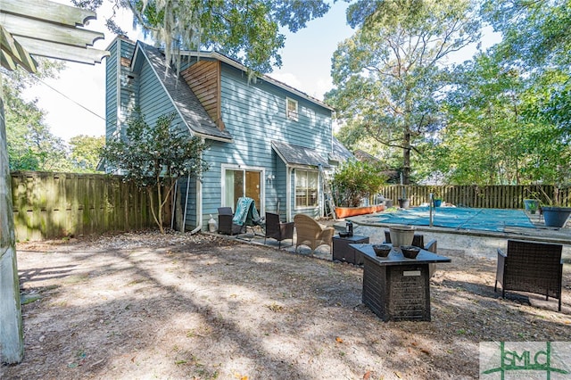 back of property featuring a fenced backyard, a chimney, and a shingled roof