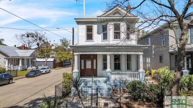 view of front of property with a fenced front yard and covered porch