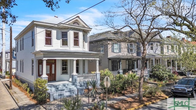 view of front of house with a fenced front yard and a porch