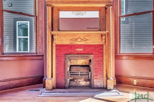 room details featuring visible vents, wood finished floors, and a fireplace