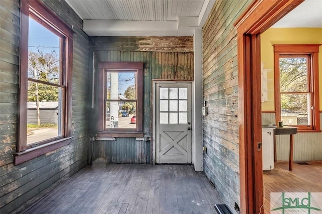 interior space featuring hardwood / wood-style flooring, plenty of natural light, and wood walls