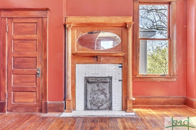 details with a fireplace, baseboards, and wood finished floors