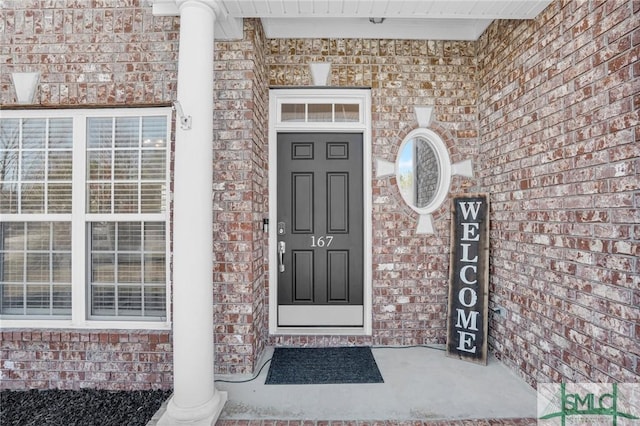 doorway to property featuring brick siding