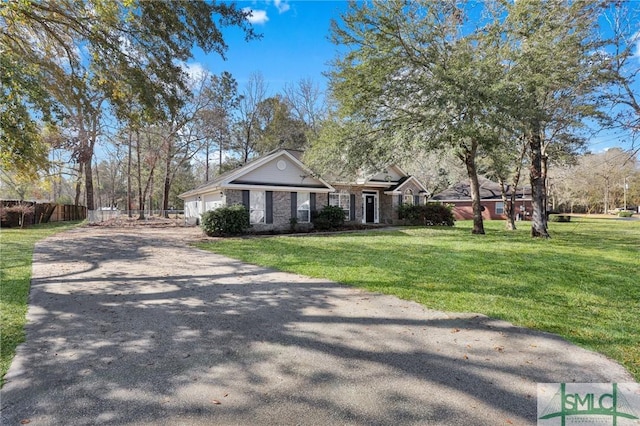 view of front facade with a garage, driveway, a front yard, and fence