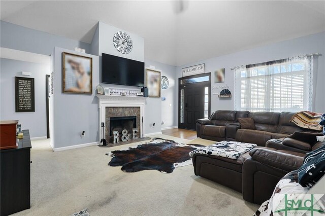 living area with carpet flooring, a fireplace, and baseboards