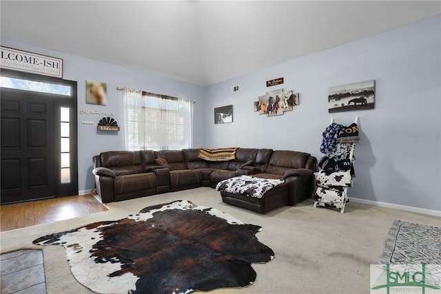 carpeted living room with vaulted ceiling, visible vents, and baseboards