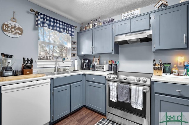 kitchen featuring under cabinet range hood, dishwasher, light countertops, stainless steel electric range, and a sink