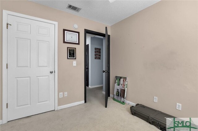 carpeted bedroom with baseboards, visible vents, and a textured ceiling