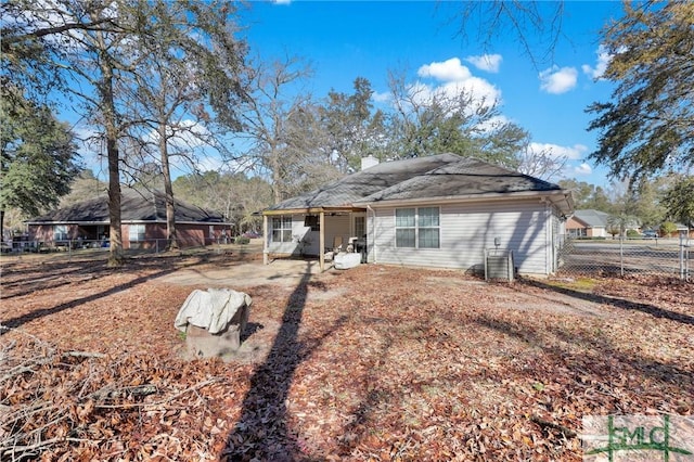 back of house with a chimney and fence