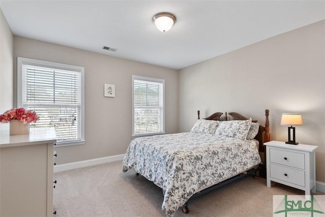 bedroom with visible vents, baseboards, and light colored carpet