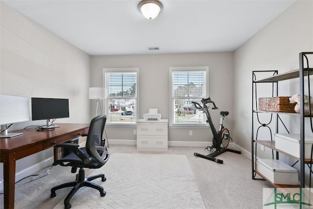 office featuring visible vents, light carpet, and baseboards