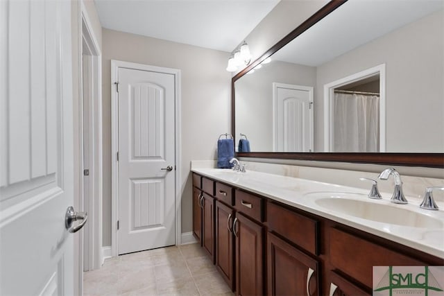 full bathroom with a sink, double vanity, and tile patterned flooring