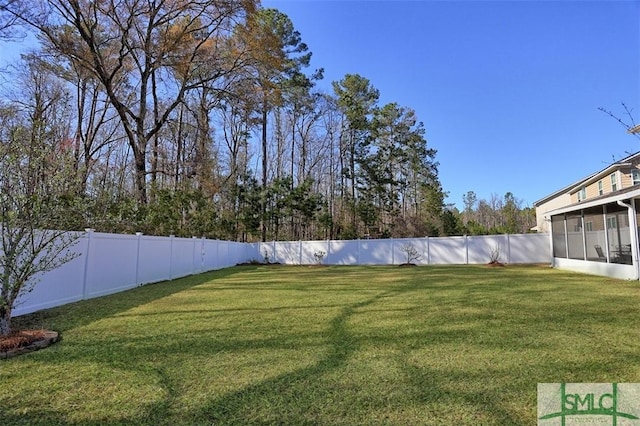 view of yard featuring a fenced backyard and a sunroom