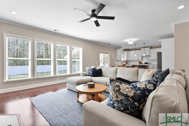 living room with visible vents, baseboards, ornamental molding, recessed lighting, and wood finished floors