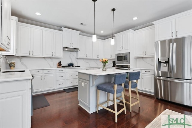 kitchen featuring a sink, under cabinet range hood, a center island, stainless steel appliances, and white cabinets