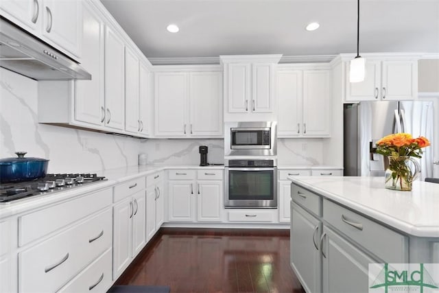 kitchen with under cabinet range hood, stainless steel appliances, white cabinets, and light countertops