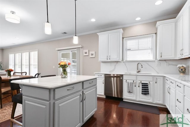 kitchen featuring a kitchen island, dark wood-type flooring, dishwasher, light countertops, and a sink