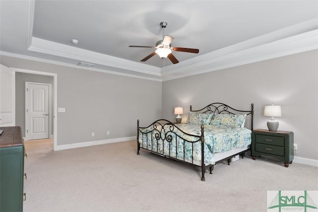 bedroom with visible vents, crown molding, baseboards, a tray ceiling, and light carpet