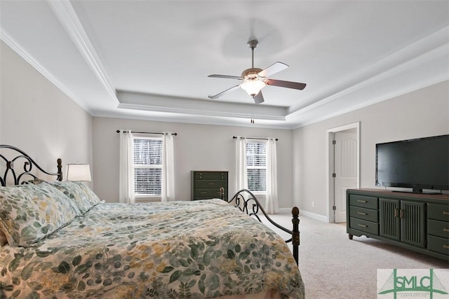 bedroom with light colored carpet, a raised ceiling, baseboards, and multiple windows