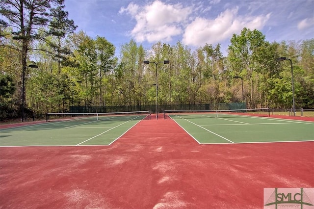 view of tennis court with community basketball court and fence