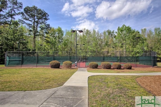 view of sport court featuring a yard and fence