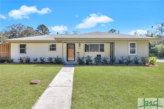 ranch-style house with a front yard, fence, and brick siding