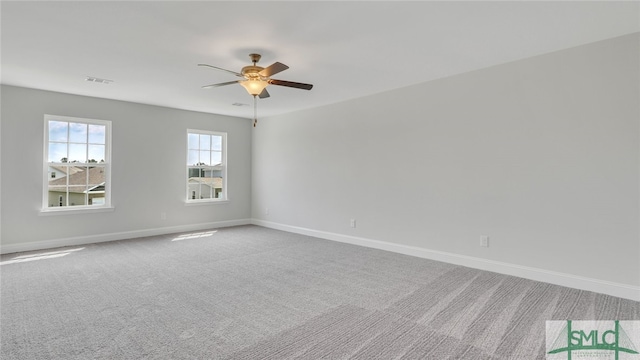 carpeted empty room with visible vents, baseboards, and a ceiling fan