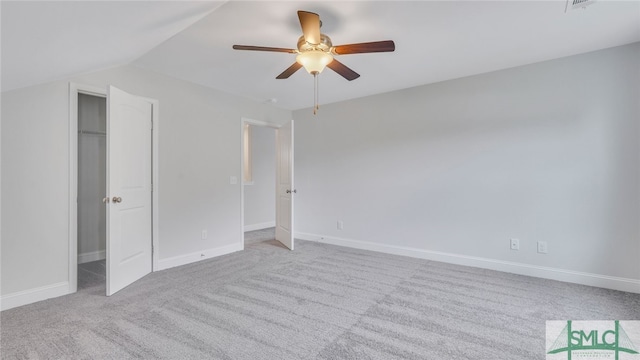 unfurnished bedroom featuring lofted ceiling, carpet, baseboards, and ceiling fan