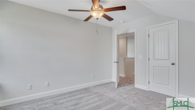 unfurnished bedroom featuring lofted ceiling, carpet flooring, a ceiling fan, and baseboards