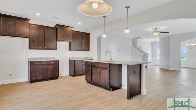 kitchen featuring light wood-style flooring, dark brown cabinets, and a sink