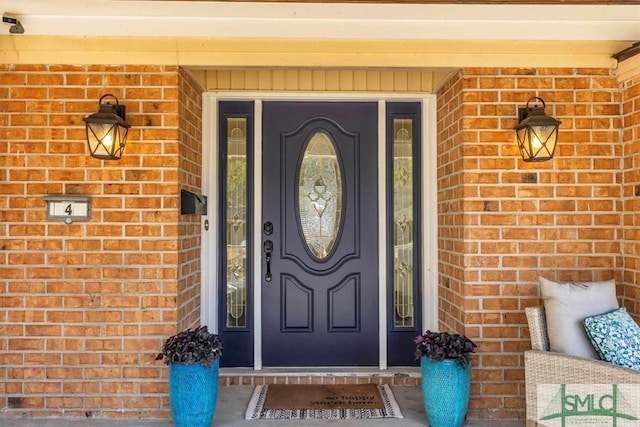 property entrance featuring brick siding and a porch